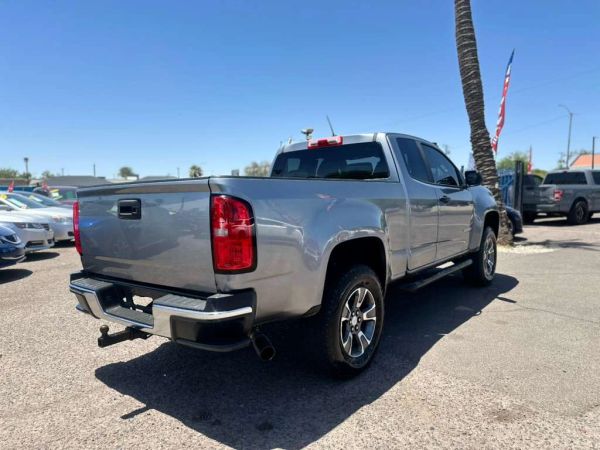 Silver pickup truck parked outdoors under clear blue sky.