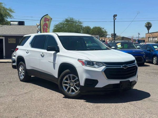 White Chevrolet Traverse SUV parked in a lot on a sunny day.