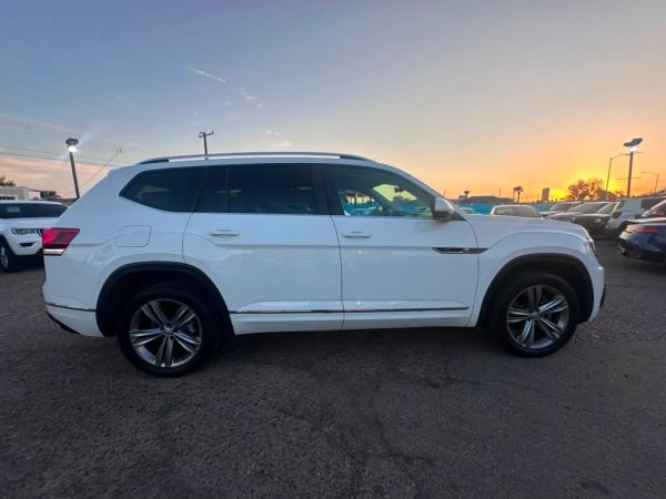 Side view of a white SUV at sunset.