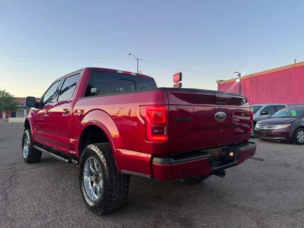 Red Ford F-150 pickup truck parked outside at sunset.