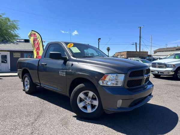 Gray 2015 Ram 1500 pickup truck parked in a lot on a sunny day.