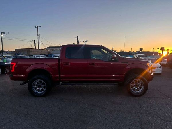 Red pickup truck parked at sunset in a lot.