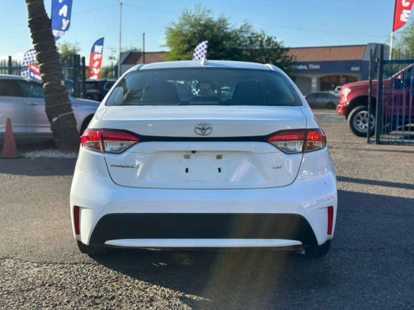 Rear view of a white Toyota Corolla parked outdoors with no license plate.