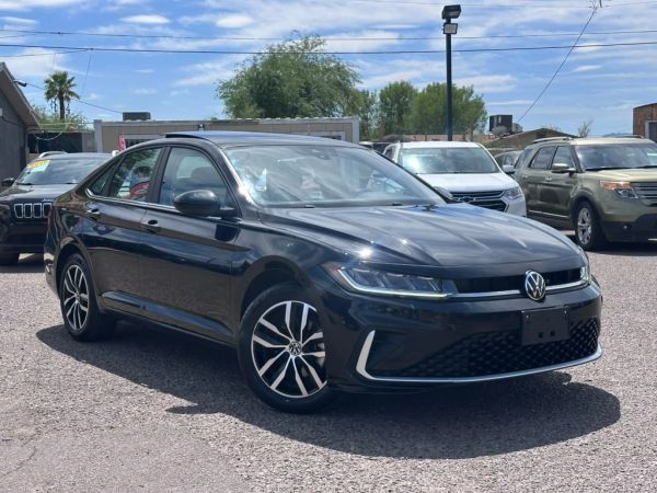 Black Volkswagen sedan parked in a lot on a sunny day.