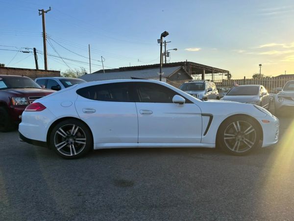 White luxury sports sedan parked at sunset.