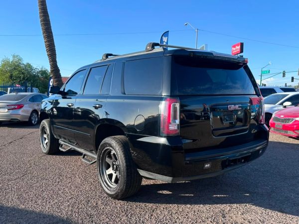 Black GMC SUV parked outside on a sunny day.