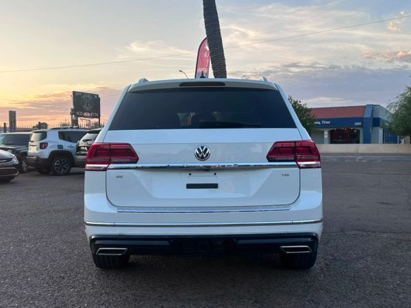 Rear view of a white Volkswagen SUV at sunset.