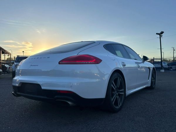 White Porsche Panamera parked at dusk.