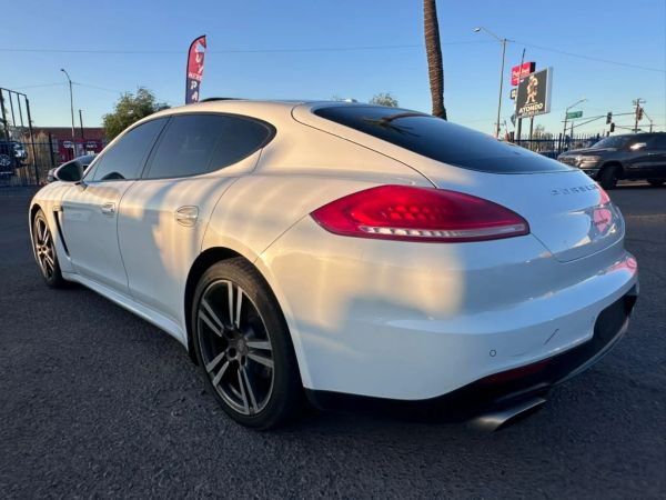 White Porsche sports car parked outdoors at sunset.
