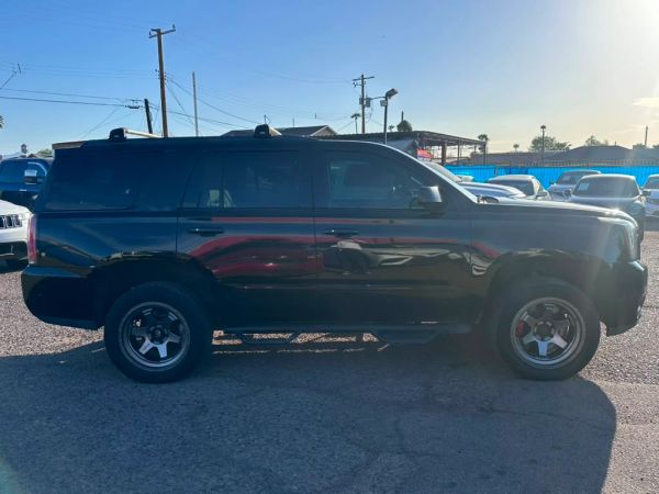 Black SUV parked in a lot with sunlight glare.