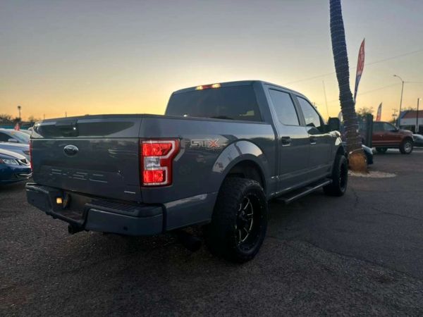 Gray Ford F-150 STX truck parked at sunset.