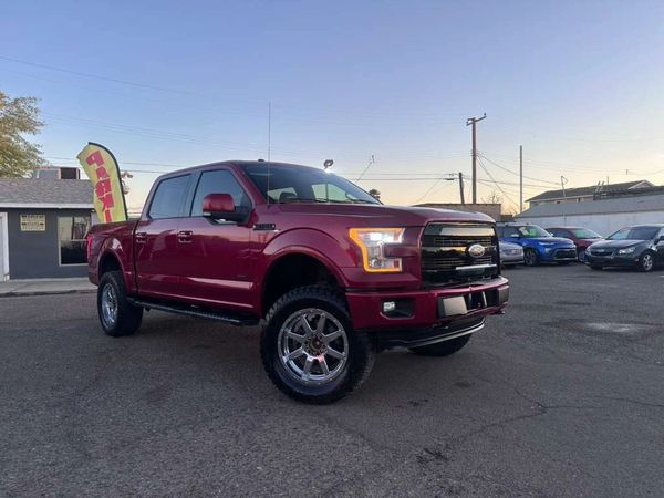 Red Ford pickup truck parked in a lot during sunset.