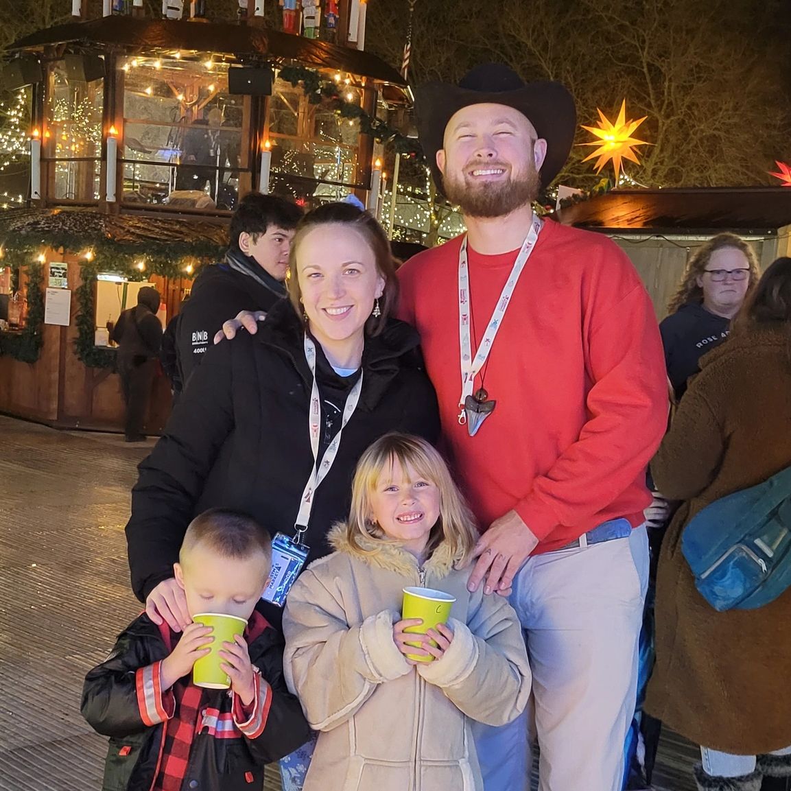 Family enjoying a festive night with warm drinks and holiday lights.