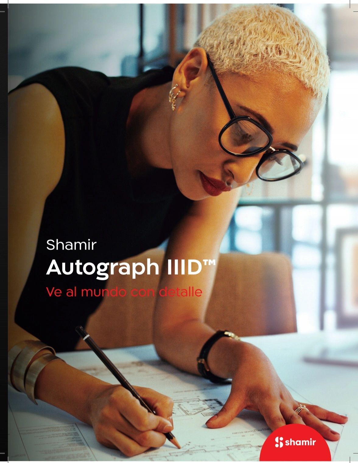 Woman wearing Shamir Autograph IIID glasses, focused on drawing detailed plans.