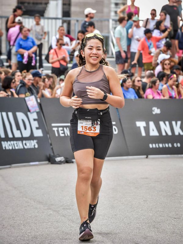 A smiling female runner in a race with bib number 1563 named Michelle.