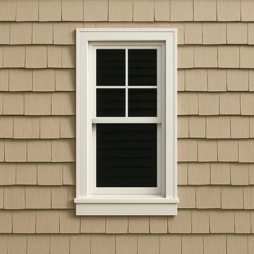 A white-framed window on a beige shingle wall.