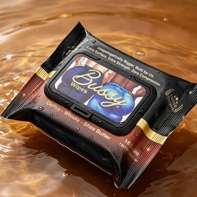 Pack of Busby wipes with coffee, whisky, and shea butter floating on liquid.