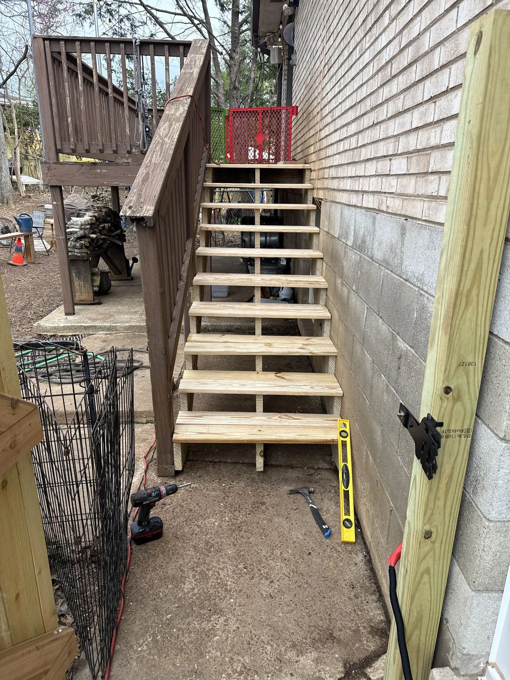 Newly built wooden stairs attached to a brick wall.