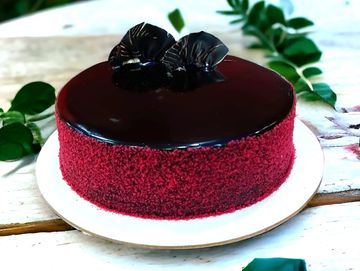 Chocolate-glazed red velvet cake with decorations.