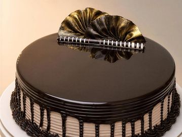 A round chocolate cake with decorative chocolate frosting.