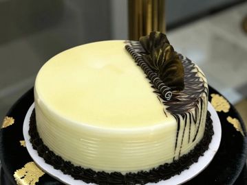 Elegant round cake with creamy and chocolate decoration.