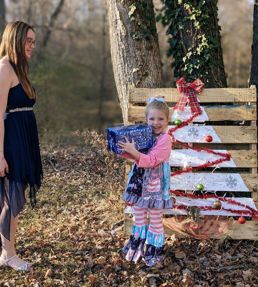 Little girl smiling holding a Christmas present