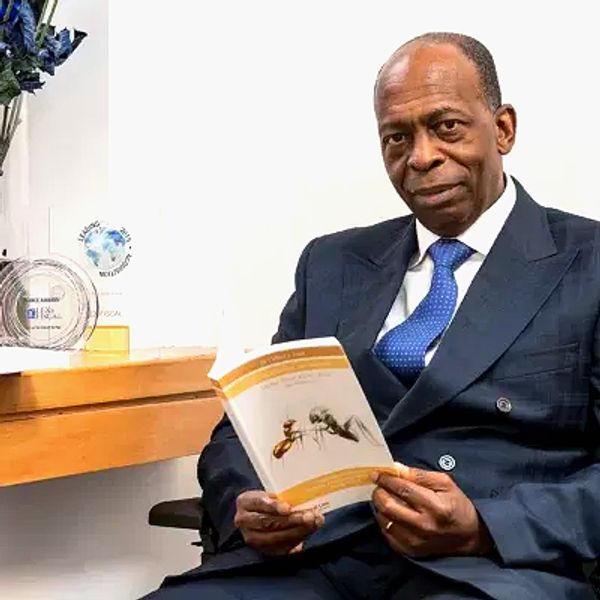 Dr Clifford John Frank holding UK tax questions answers. His book that he has published