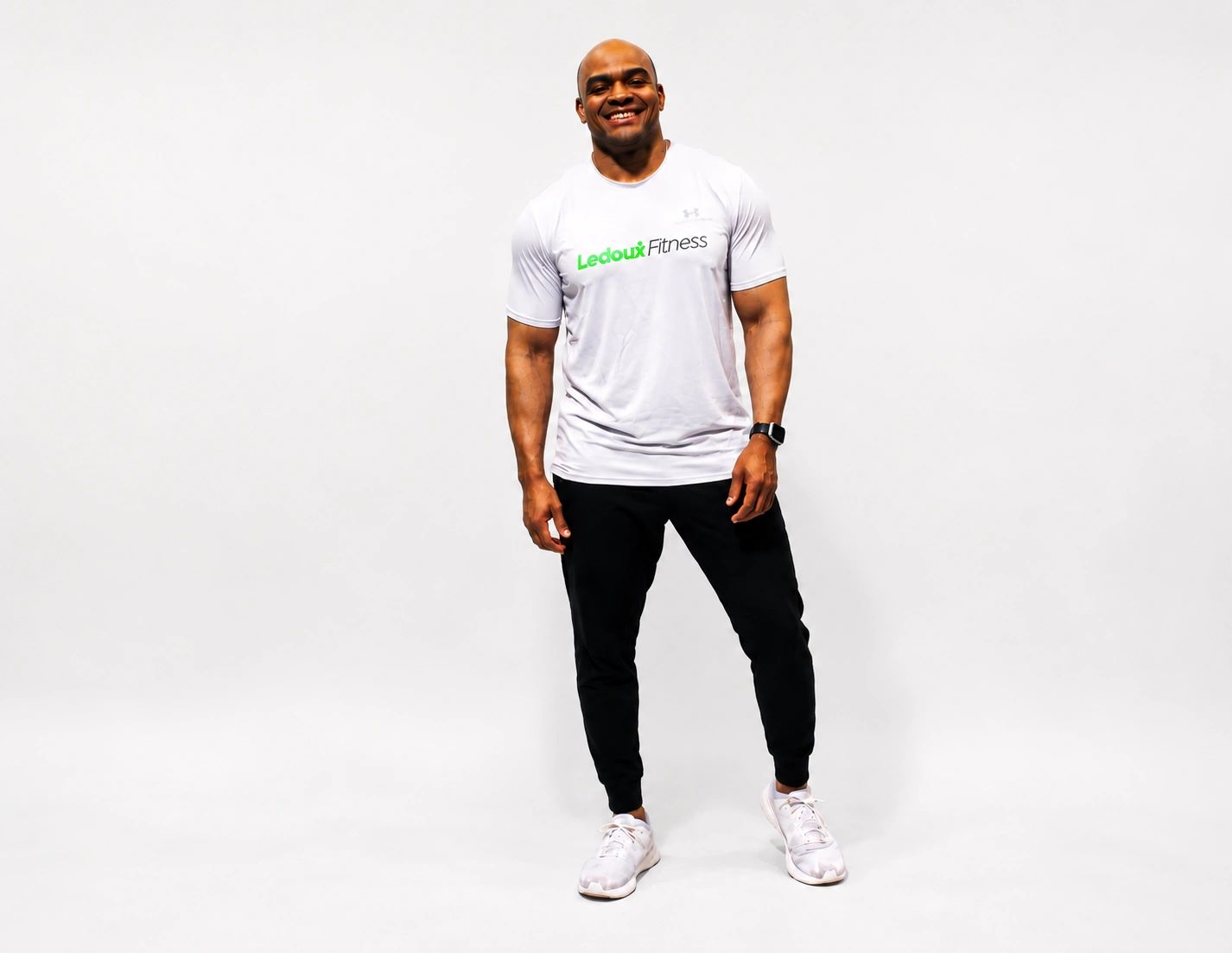 Smiling fit man in a fitness t-shirt and black pants.