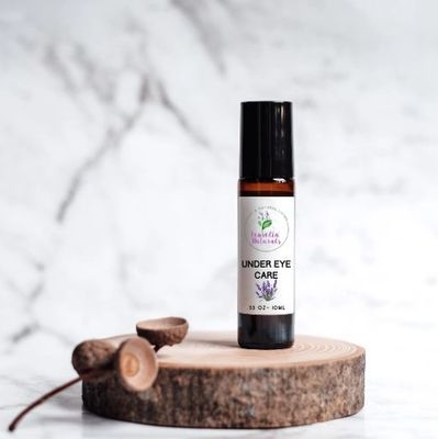 Under eye care serum on a wooden platform with acorns.