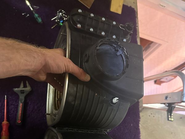 Hand holding a large black filter.






