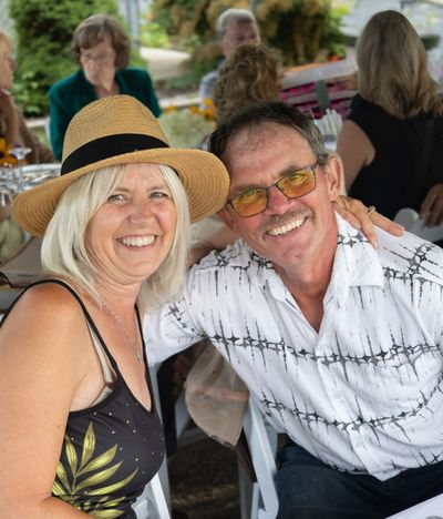 Smiling couple enjoying a social gathering outdoors.