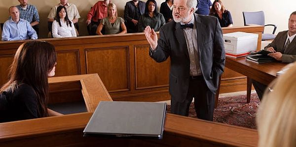 A lawyer passionately addressing a witness in a courtroom.