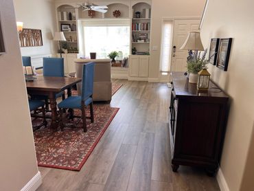 Cozy living and dining room with blue chairs and wooden furniture.