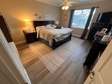 Cozy bedroom with a large bed, wooden furniture, and soft lighting.