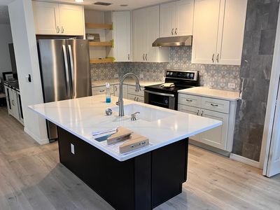 Modern kitchen with a large island and stainless steel appliances.
