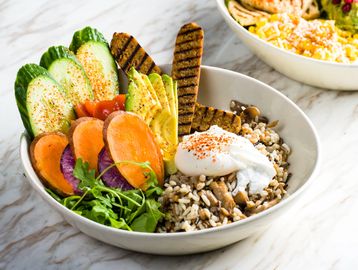 BKLYN Wild Beast Bowl with grains, sausage, avocado, egg, fresh vegetables, and greens.