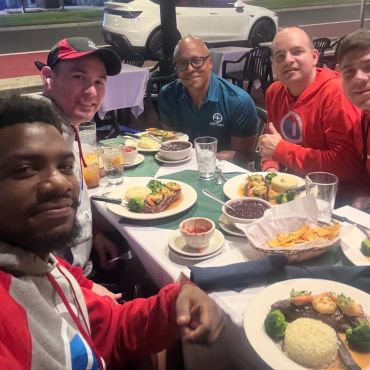 A group of friends enjoying dinner outdoors at night.