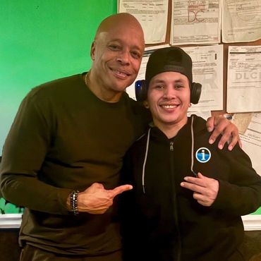 Two men posing for a photo indoors with cheerful expressions.