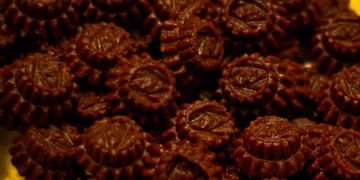 Close-up of dark brown patterned chocolates piled together.