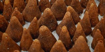 Rows of brown, cone-shaped sweets arranged closely together.