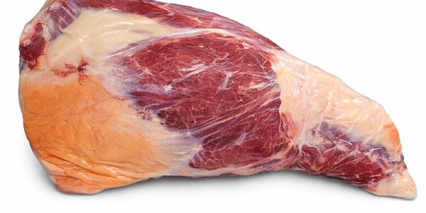 A fresh raw beef cut with visible fat and muscle texture.
