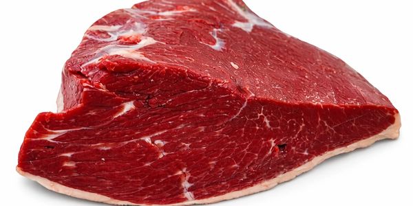 A raw piece of beef steak with visible marbling on a white background.