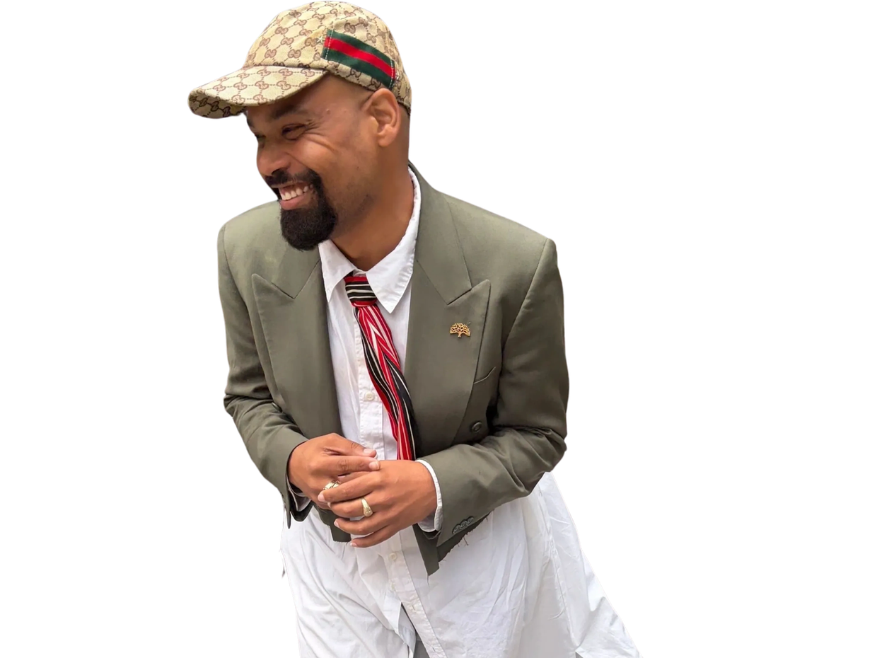 Man smiling with stylish hat and blazer.