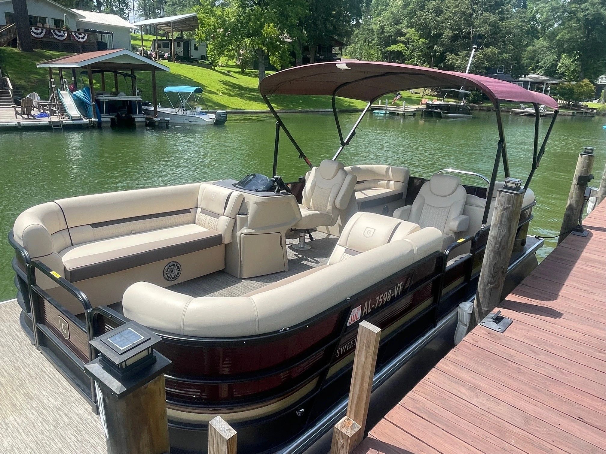 Luxury pontoon boat docked at a lake.
