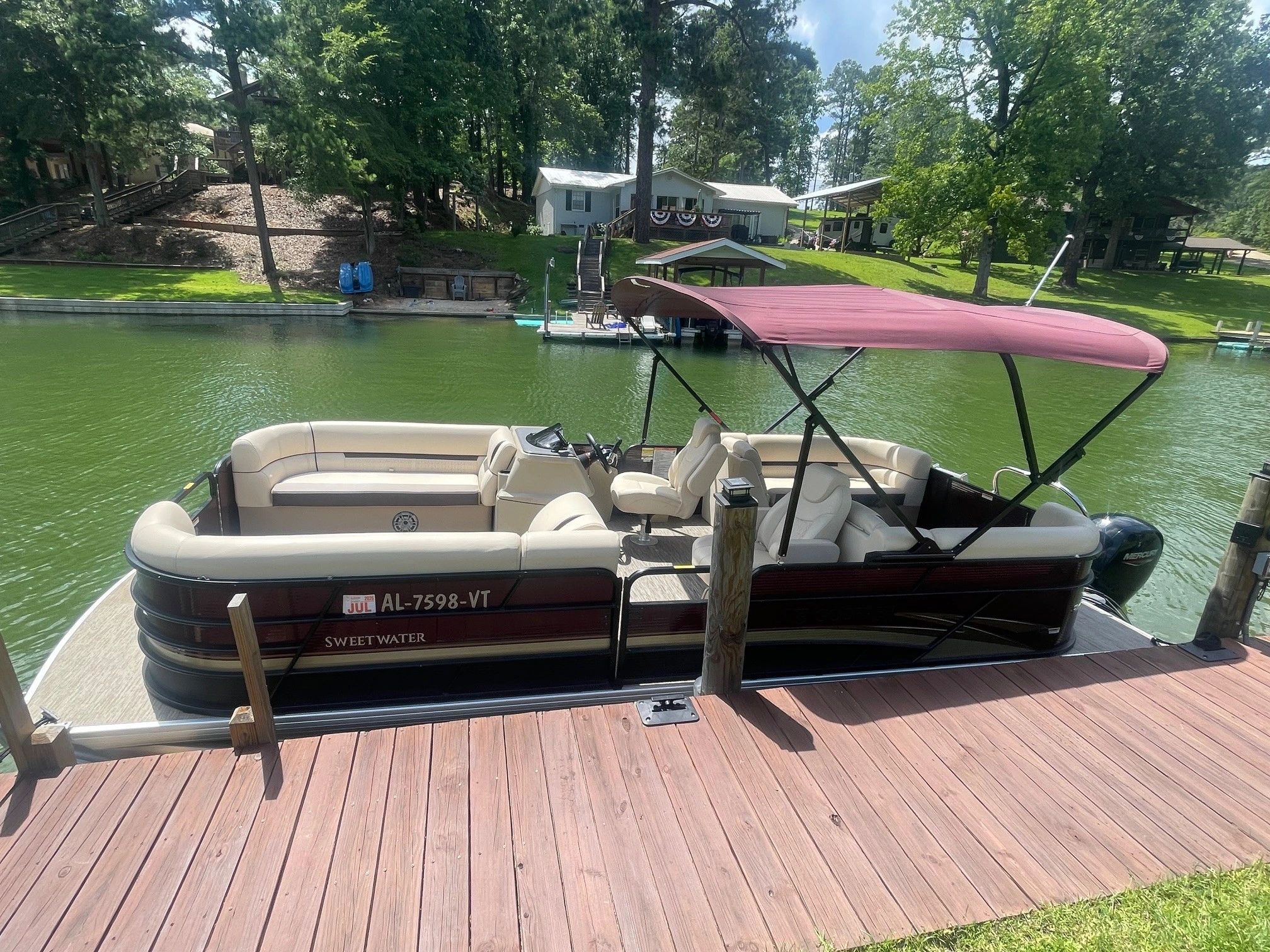 Pontoon boat docked at a peaceful lakeside cabin.
