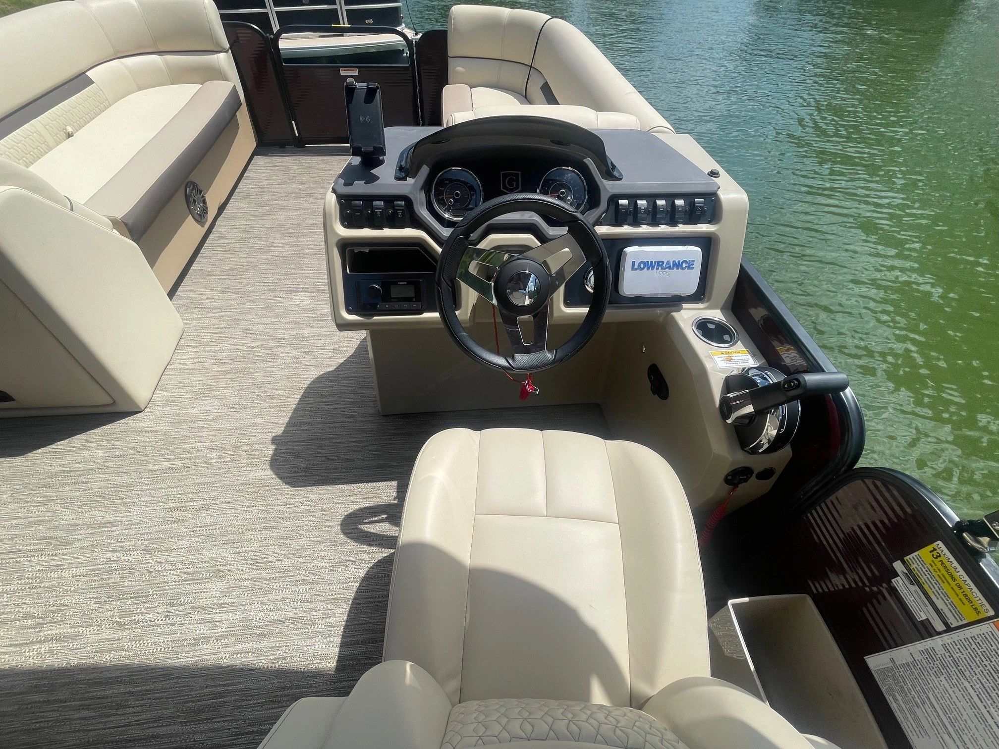 Interior view of a pontoon boat with steering wheel and seating.