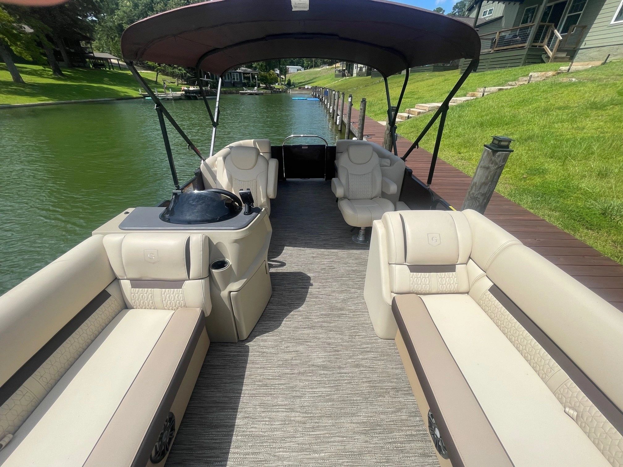 Interior view of a pontoon boat on a lake.
