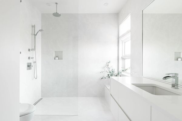 interior design renovated bathroom with curbless shower and large tile slabs with rain shower head 