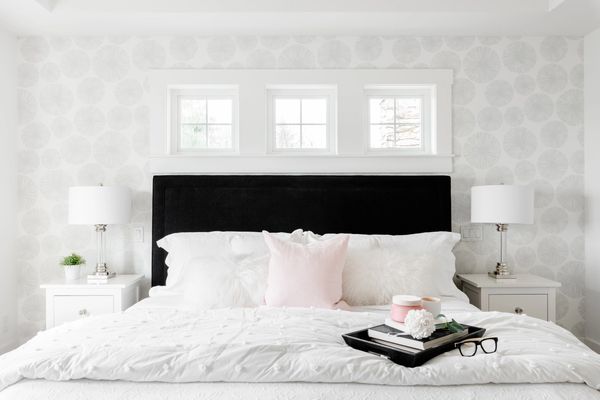 interior design master bedroom with white  grey wallpaper and black upholstered bed + transom window