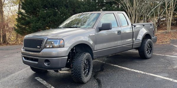 Gray pickup truck parked outdoors on asphalt.